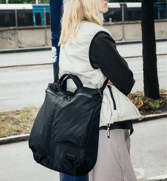 Db(ディービー)の「Utility Tote 32L」ブラック。スポーツや旅行に最適な、32Lの大容量で機能的なトートバッグのモデル着用画像です。