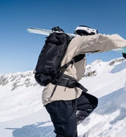 アクティブな男女向けのリュック、Db Backcountry Backpack 25Lのスキー装着画像。旅行から本格的なアウトドアまで幅広く活躍します。