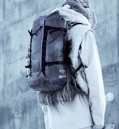  Dbの軽量バックパック「Weigh Lighter Backpack 25L」の着用画像。旅行やスポーツなどアクティブなシーンに最適です。色はWeigh Darker
