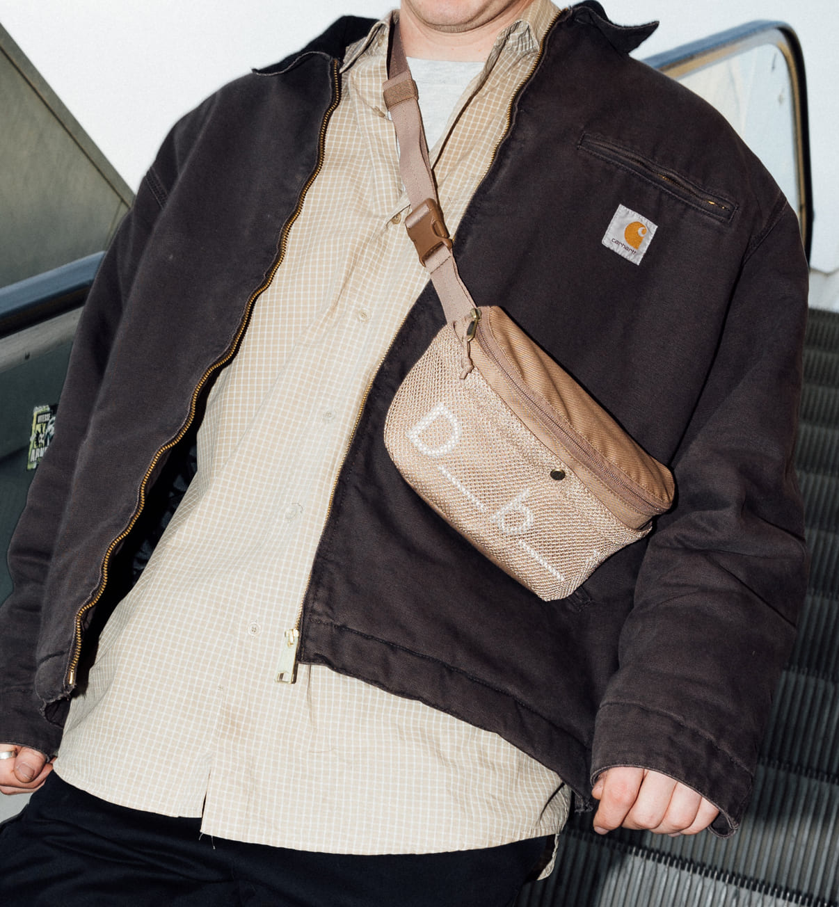 旅行やスポーツに最適なDbのボディバッグ、Hauler Sling Bag 3L。アクティブに動ける3L容量のスリングバッグ着用画像。色はAffogato Brown