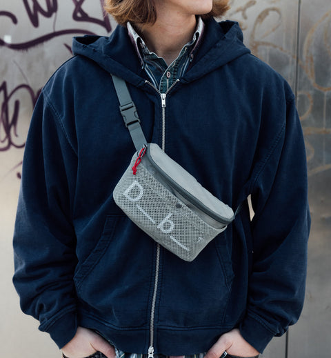 旅行やスポーツに最適なDbのボディバッグ、Hauler Sling Bag 3L。アクティブに動ける3L容量のスリングバッグ着用画像。色はBasil Green