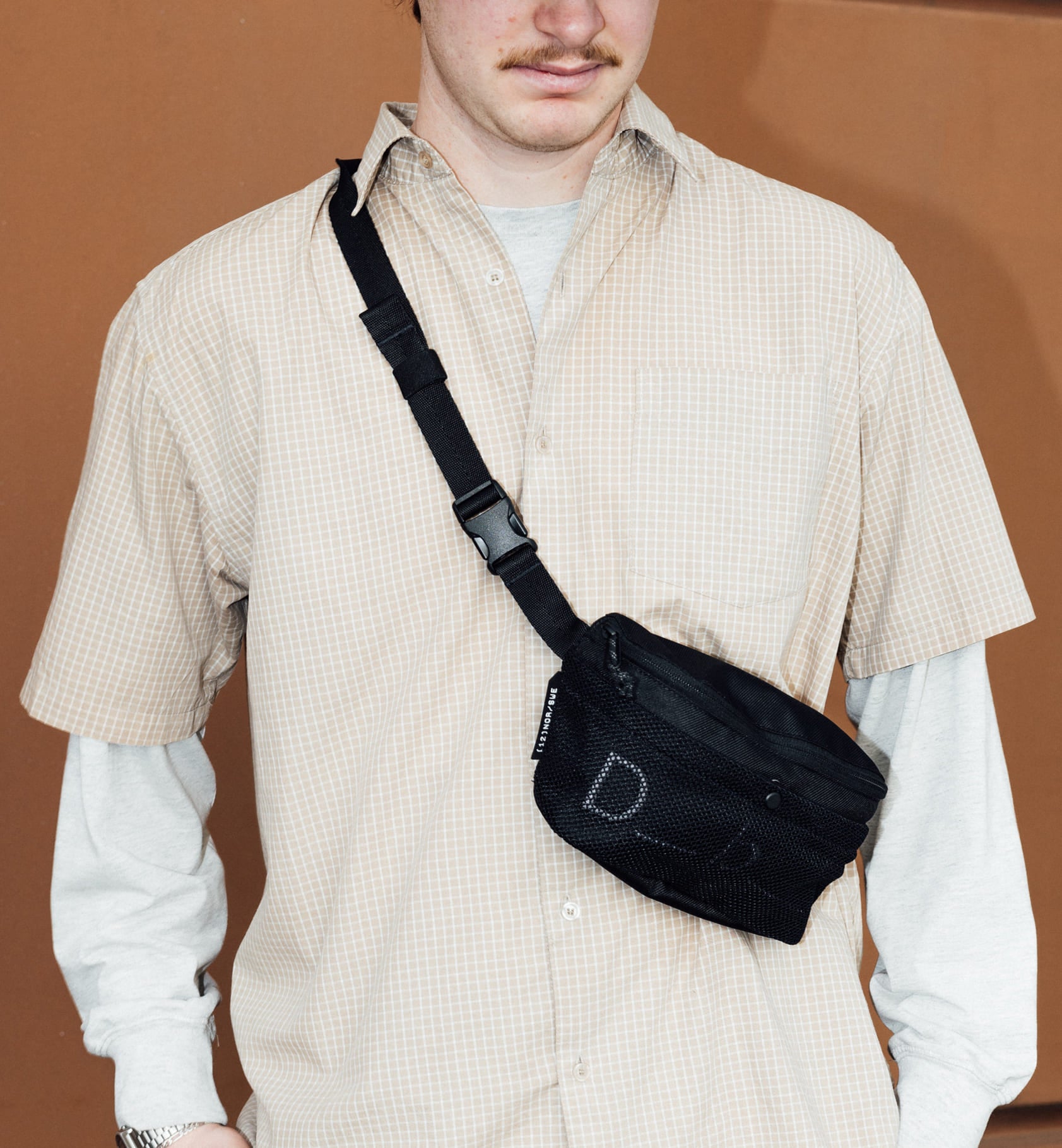Db Hauler Sling Bag 3Lの着用イメージ。スポーツや旅先での移動を快適にする、アクティブな大人向けの無駄のない洗練されたデザインのボディバッグ。

